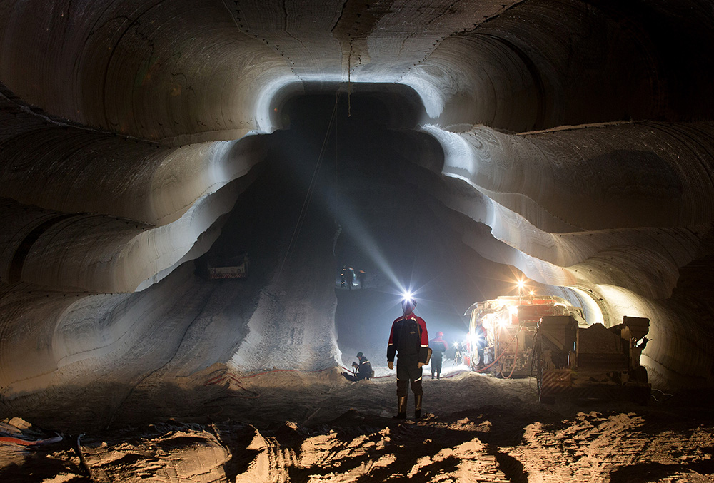 BIG DIG: An employee uses the light from a head torch to illuminate the machine cut walls of a potash mine in Berezniki, Russia. Photographed by Andrey Rudakov for Bloomberg.