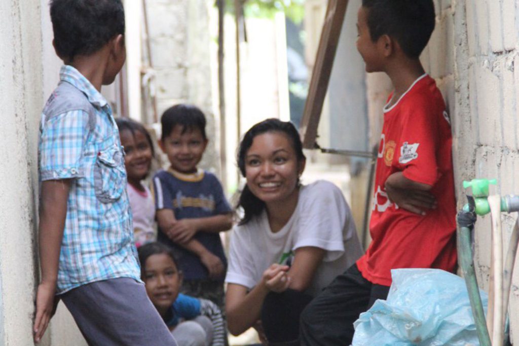 During the Batam Build, a Habitat for Humanity project, Adelaida (second from right) takes a break to converse with children.