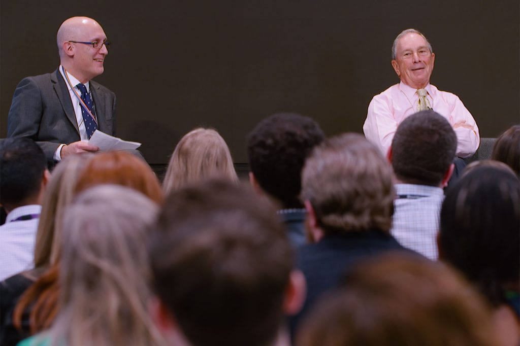 Ken Cooper and Mike Bloomberg speak with employees at the headquarters office in New York
